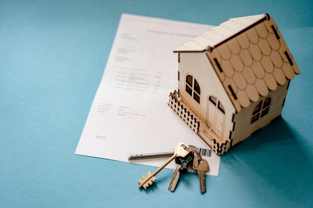 House model, keys, and contract on blue background.