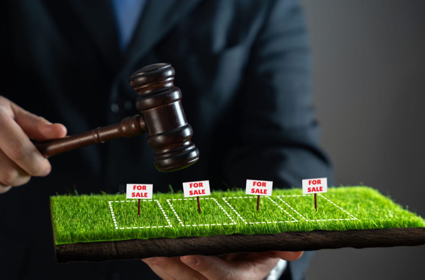 Gavel above miniature land plots for sale.