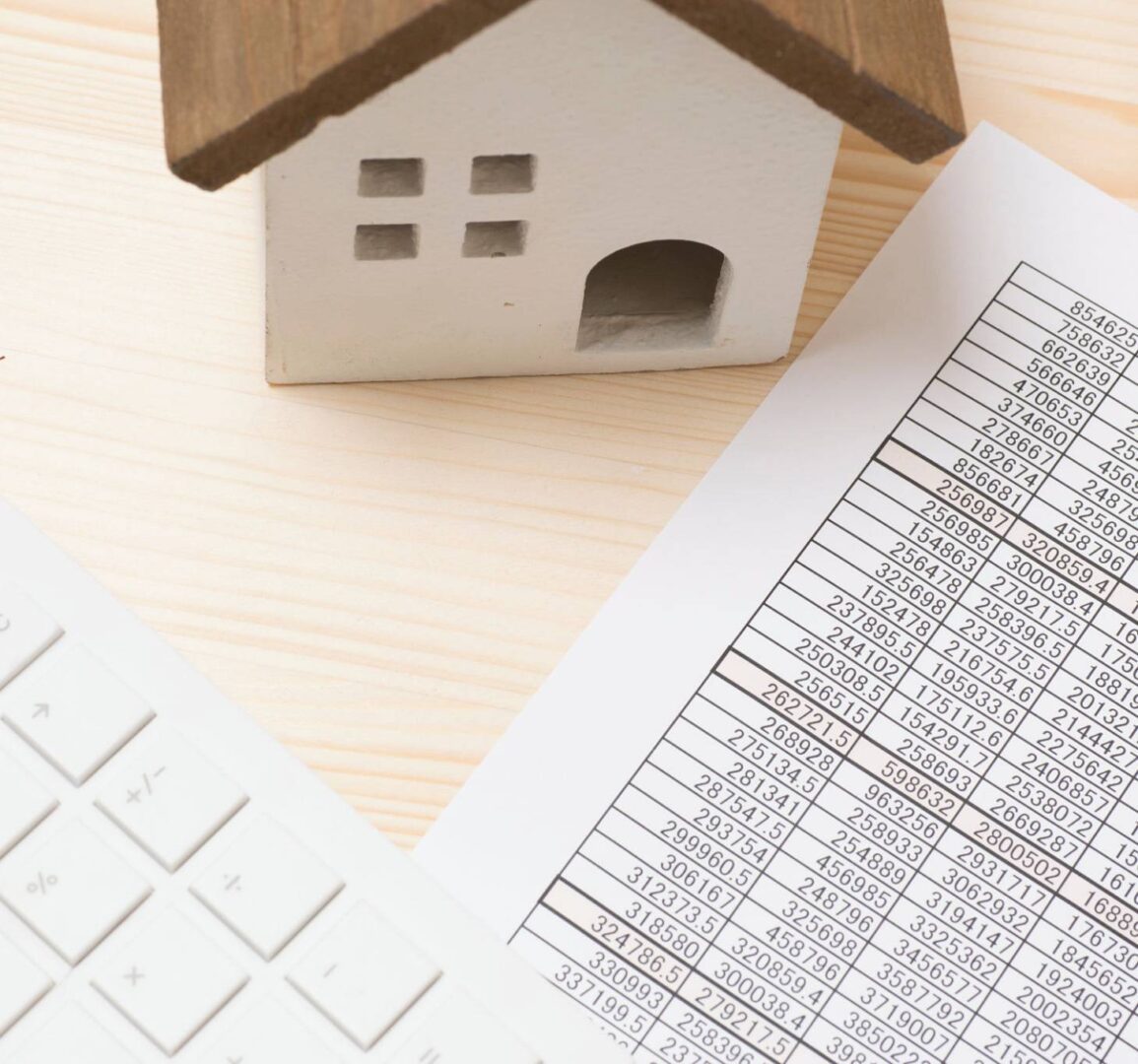 Miniature house, financial document, and keyboard.