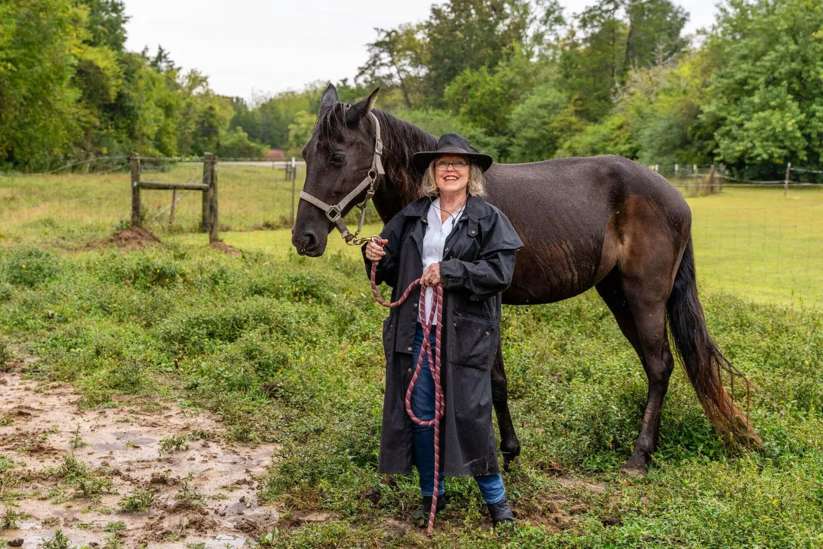 Person with horse in a grassy field.
