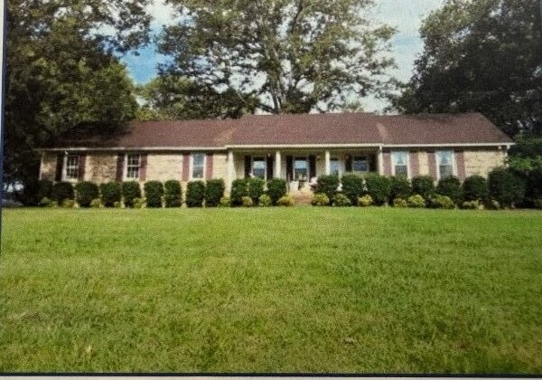Brick ranch house with lawn and trees