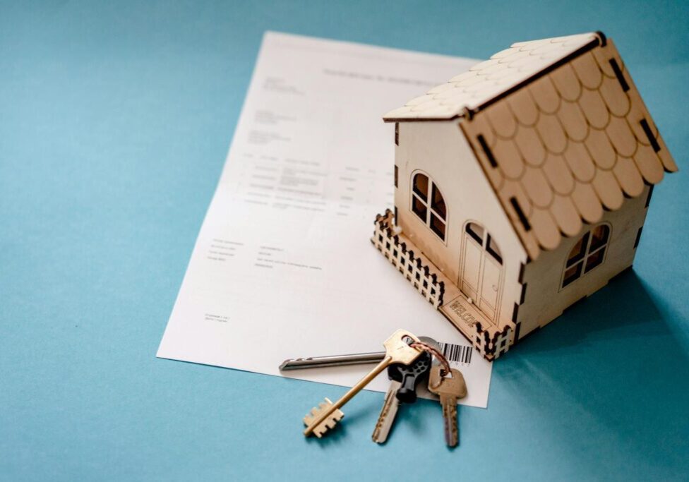 House model, keys, and contract on blue background.